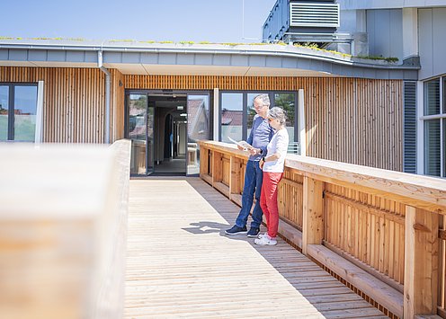 Zwei Menschen stehen auf einer Brücke zum Thalasso-Gesundheitszentrum auf Spiekeroog 