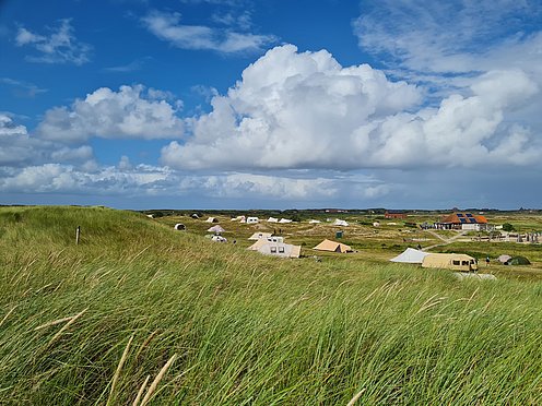 Blick von der Düne auf den Spiekerooger Zeltplatz mit schöner Wolkenformation.