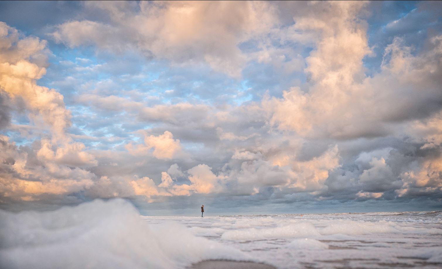 Spiekerooger Strand im Herbst mit Schaum und beeindruckenden Wolken am Himmel