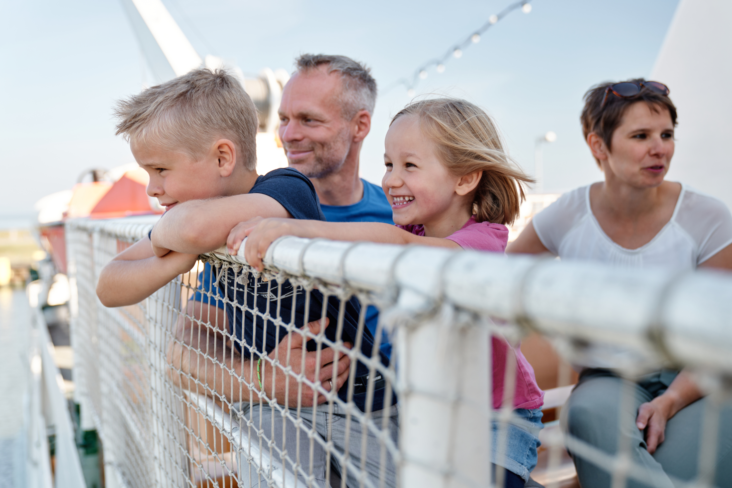 Eine Familie sitzt auf dem Sonnendeck des Schiffes Spiekeroog2 auf dem Weg nach Spiekeroog.