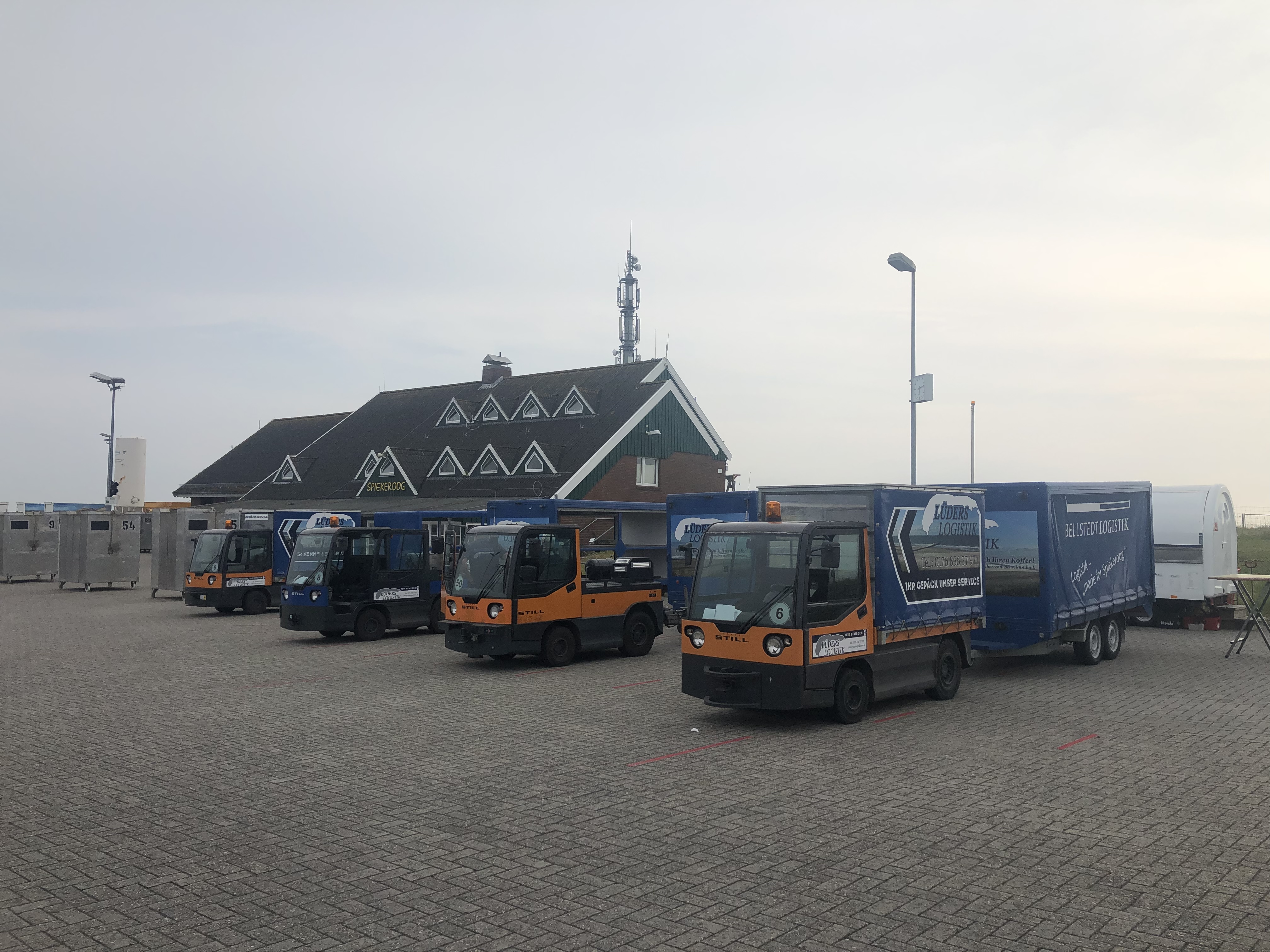 Elektrokarren warten am Hafen Spiekeroog darauf das Gepäck ins Dorf zu transportieren.