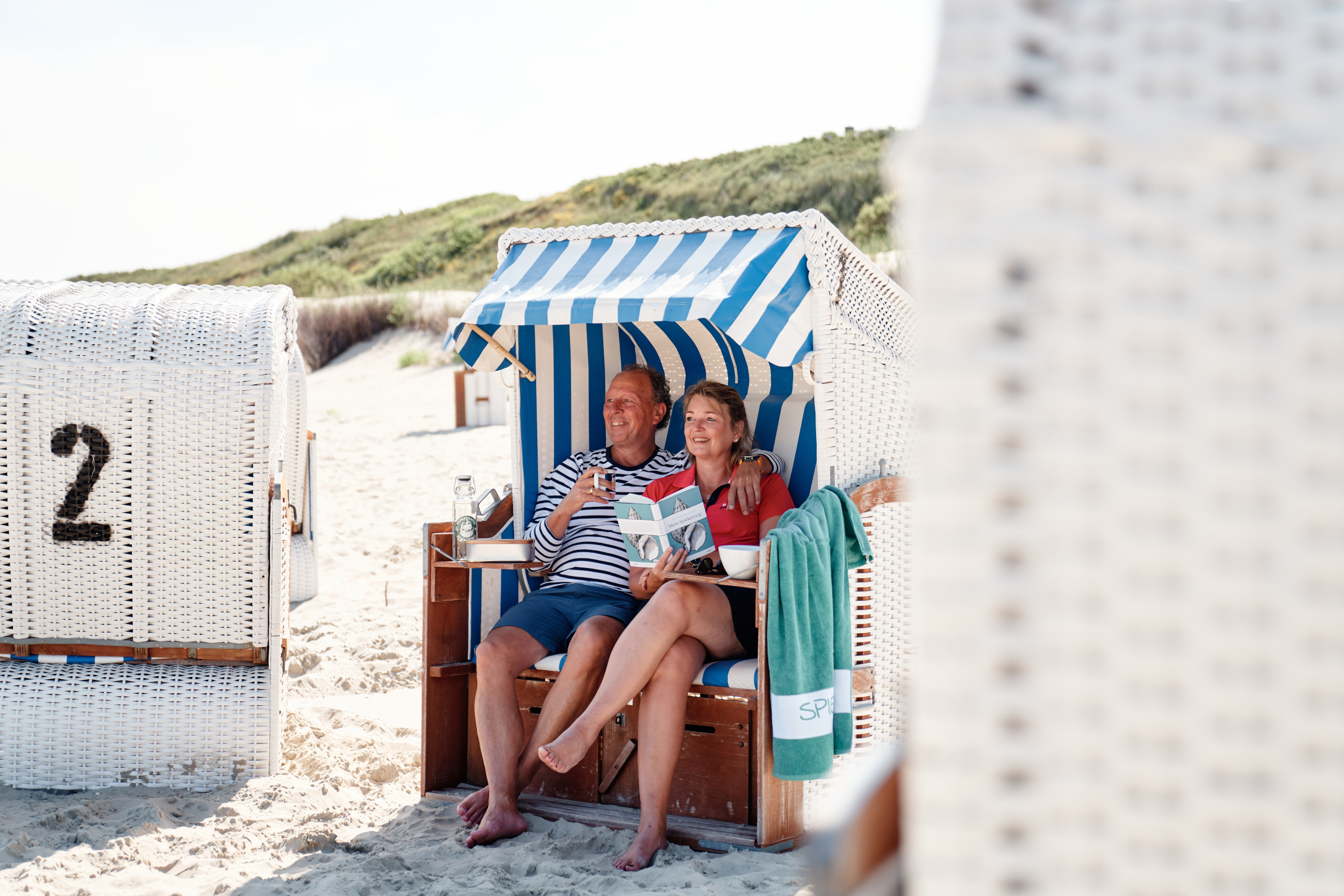 Ein Paar sitzt am Spiekerooger Strand im Strandkorb
