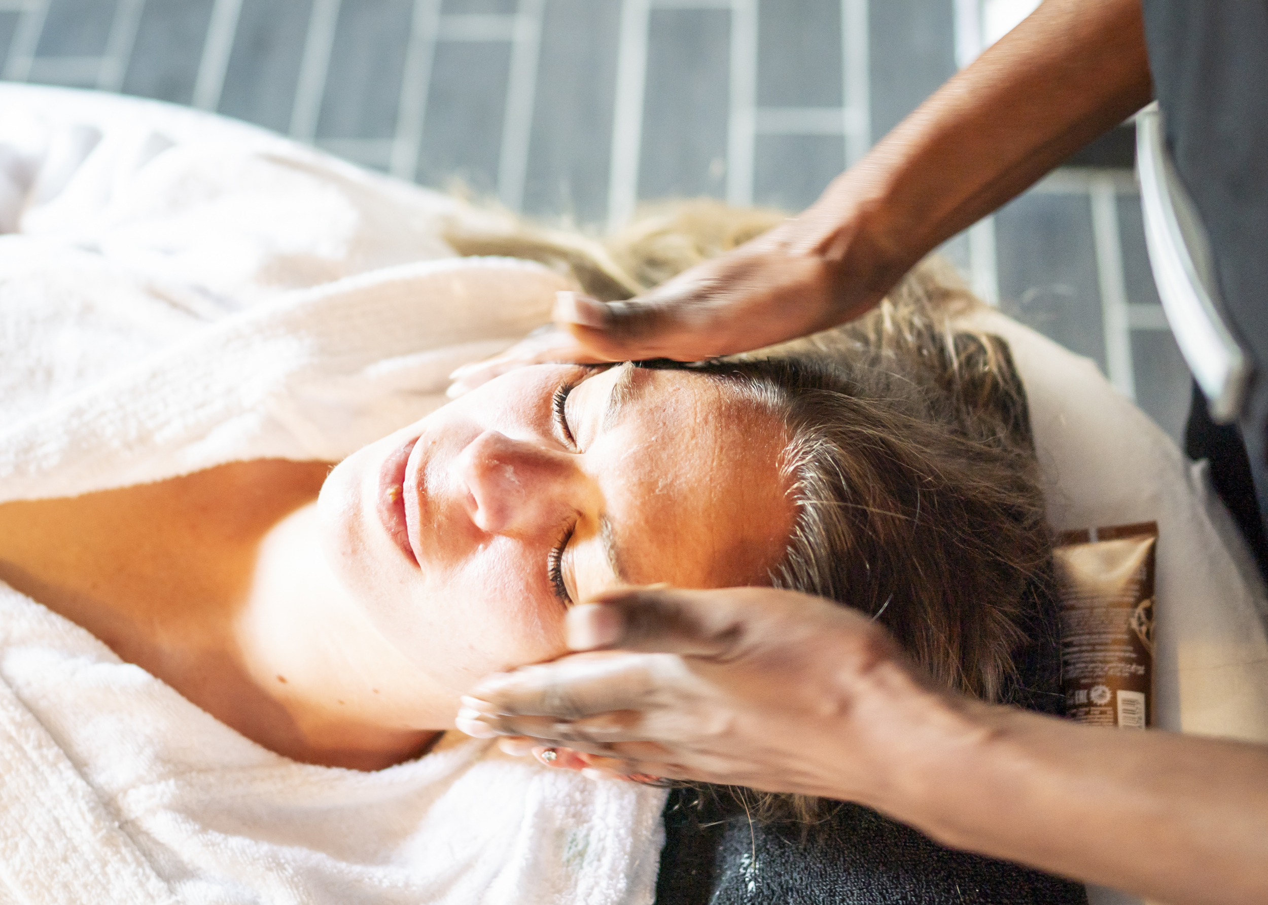 Eine Frau erhält eine Gesichtsbehandlung von einer Mitarbeiterin des DünenSpa im Meerestied auf Spiekeroog.