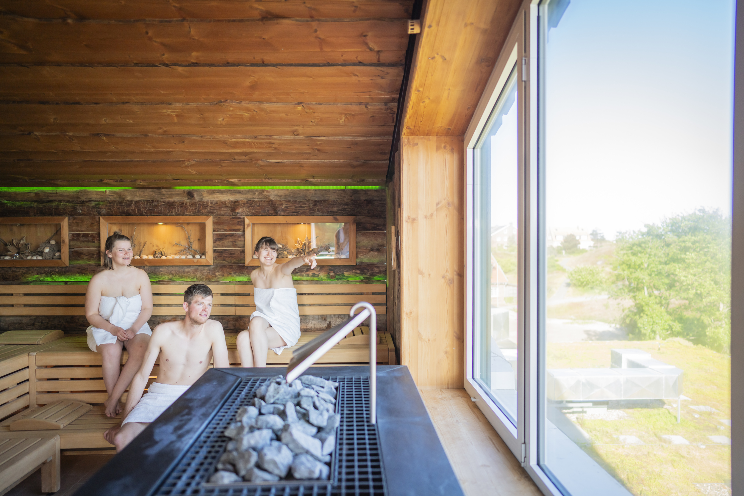 Drei Personen sitzen in der Dünensauna im DünenSpa Im Meerestied auf Spiekeroog.