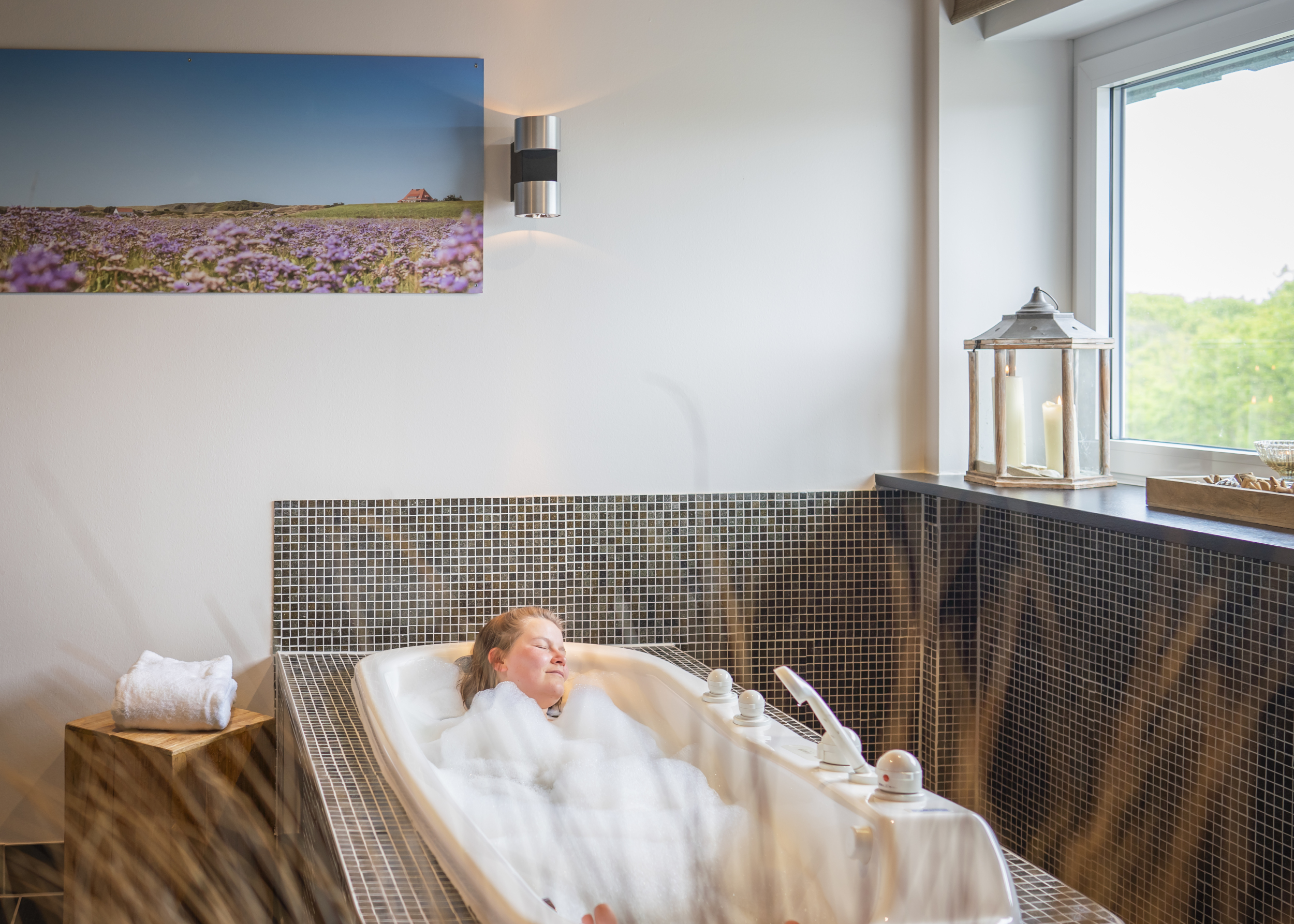 Eine Frau genießt ein Wannenbad im Thalasso-Gesundheitszentrum, im Meerestied auf Spiekeroog