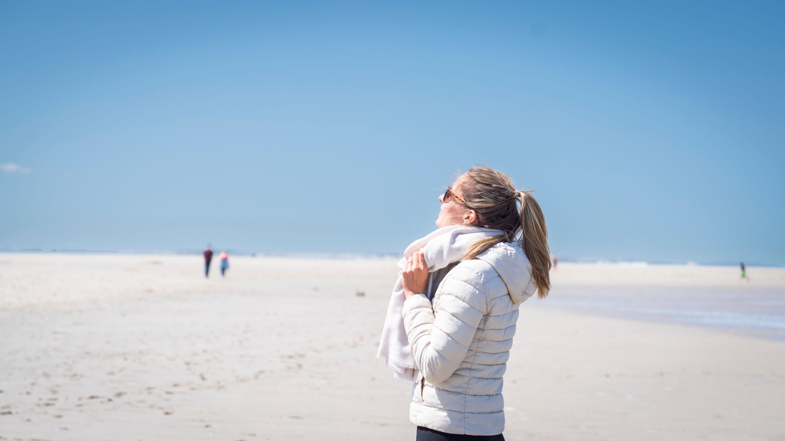 Eine Frau steht am Spiekerooger Strand und atmet durch 