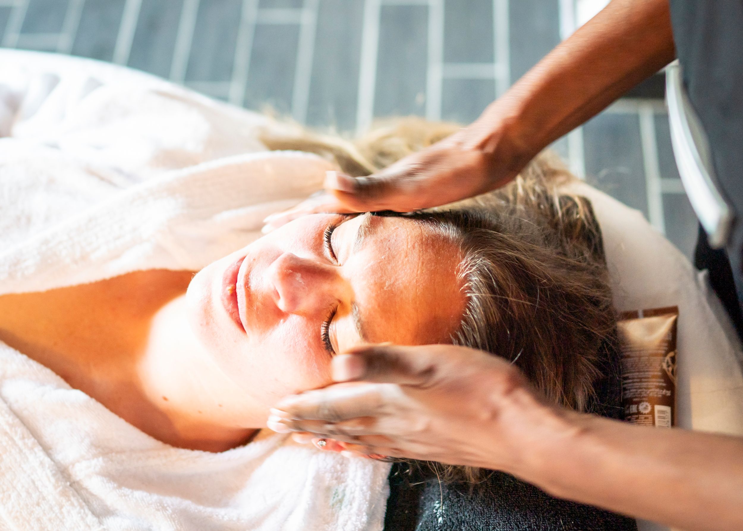 Eine Frau erhält eine Gesichtsbehandlung von einer Mitarbeiterin des DünenSpa im Meerestied auf Spiekeroog.