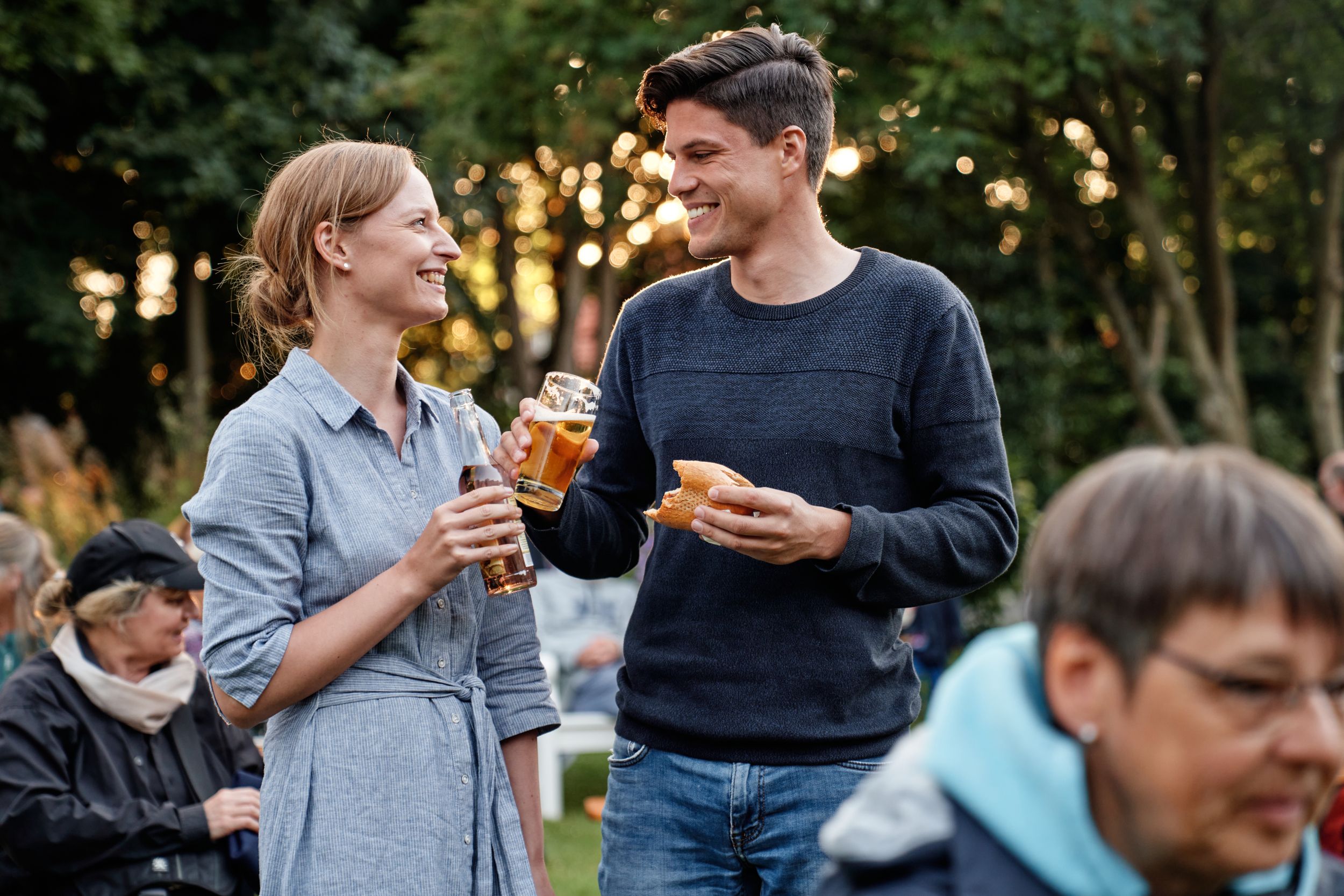 Zwei Menschen essen und trinken beim Kurparkkonzert auf Spiekeroog